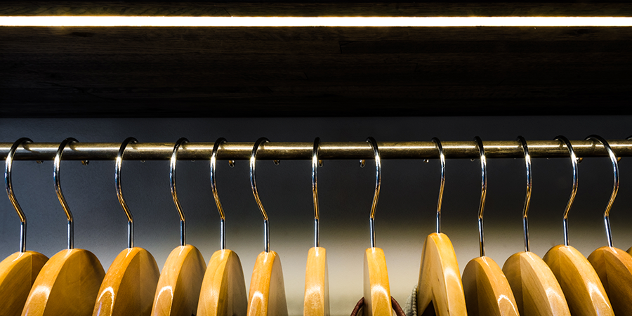 Wardrobe with wooden hangers and overhead LED strip lighting