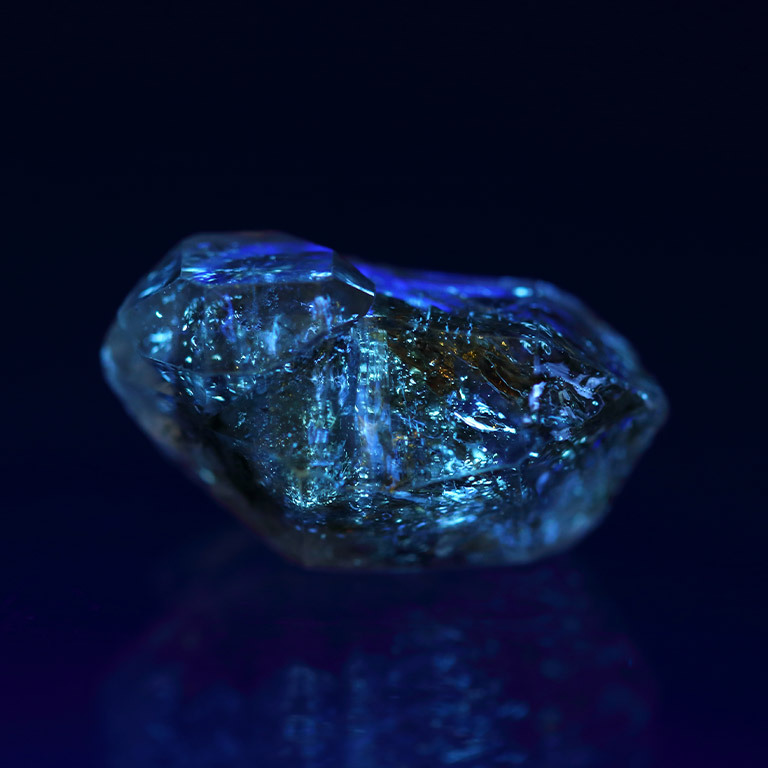 mineral-that-glows-when-illuminated-by-ultraviolet-light Mineral glowing under ultraviolet light