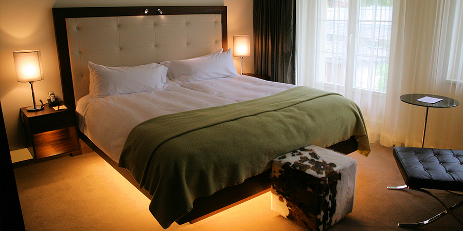 Cozy bedroom with under-bed lighting and large headboard