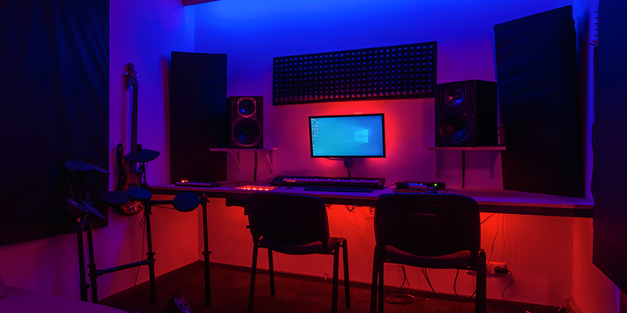 music-studio-rgb-red-and-blue-led-lighting-setup Music studio with RGB red and blue LED lighting, featuring computer, speakers, and instruments.