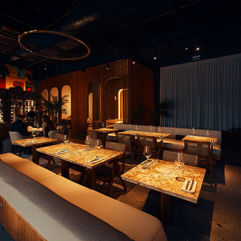 Restaurant Dining Warm LED Lighting Modern Decor A chic and modern restaurant featuring warm LED lighting, stylish wood paneling, and marble-topped tables set with wine glasses and cutlery, creating an elegant dining atmosphere.